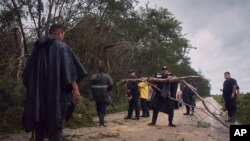 Police clear debris from a road after the passing of Hurricane Delta in Tizimin, Mexico, Oct. 7, 2020. 