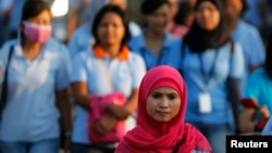 Seorang pekerja pabrik sepatu pulang kerja setelah pulang kerja, di kawasan industri Pasar Kemis di Tangerang 13 Agustus 2014. (Foto: Reuters)