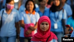 Seorang buruh perempuan pabrik sepatu pulang setelah jam kerja usai di kawasan industri Pasar Kemis di Tangerang, 13 Agustus 2014.