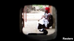 Une femme est assis dans l'enceinte d'une clinique à Bujumbura, au Burundi, le 18 avril 2006.