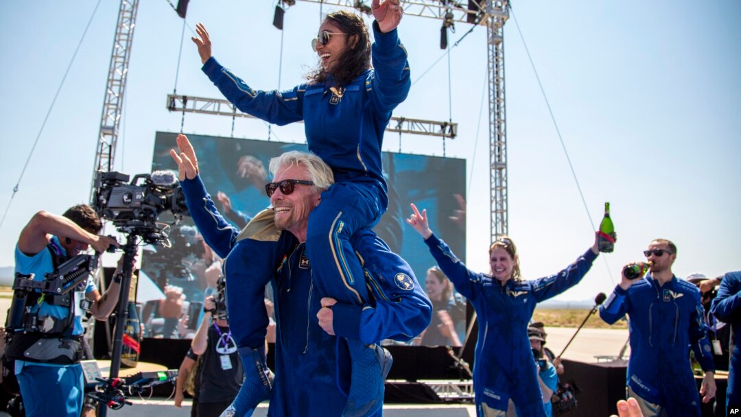 Pengusaha Richard Branson memanggul Sirisha Bandla saat merayakan keberhasilan peluncuran "Unity" ddekat Consequences, New Mexico, Minggu (11/3). 