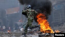 Un policier pourchasse des manifestants pro-Raila Odinga durant les troubles éclatés après la publication de la victoire du président sortant Uhuru Kenyatta à Mathare, Nairobi, Kenya, 12 août 2017. 