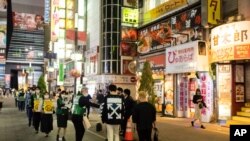 28일 도쿄 최대 유흥가인 가부키초에서 시 공무원들이 신종 코로나바이러스 방역을 위한 마스크를 나눠주고 있다.