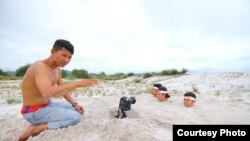 Hun Vannak (sitting) works along with his fellow environmental activists on a video campaign raising public awareness of environmental damage caused by sand dredging in Koh Kong province. (Courtesy photo of Mother Nature)