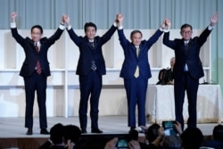 Former Foreign Minister Fumio Kishida, left, Japan's PM Shinzo Abe, Chief Cabinet Secretary Yoshihide Suga and former Defense Minister Shigeru Ishiba celebrate after Suga was elected as new head of Japan's LDP election, Sep. 14, 2020.