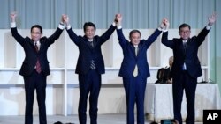Former Foreign Minister Fumio Kishida, left, Japan's Prime Minister Shinzo Abe, Chief Cabinet Secretary Yoshihide Suga and former Defense Minister Shigeru Ishiba celebrate after Suga was elected as new head of Japan's LDP, Sept. 14, 2020, in Tokyo. 