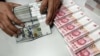 A clerk counts Chinese yuan and U.S. dollar banknotes at a branch of Bank of China in Taiyuan, China, Jan. 4, 2016. China's currency has been slipping in value since Donald Trump became president-elect. 