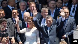 El presidente argentino, Mauricio Macri, y su esposa, la primera dama Juliana Awada, saludan a sus seguidores al salir del Congreso en Buenos Aires, tras la ceremonia de juramentación, el jueves, 10 de diciembre de 2015.