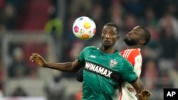 FILE - Stuttgart's Serhou Guirassy, left, heads the ball ahead of Bayern's Dayot Upamecano during the German Bundesliga soccer match between Bayern Munich and Stuttgart in Munich, Germany, Sunday, December 17, 2023.