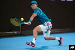 FILE - Shang Juncheng of China plays a backhand return to Frances Tiafoe of the U.S. during their second round match at the Australian Open tennis championship in Melbourne, Australia, Jan. 18, 2023.