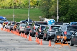 FILE - People line up to undergo coronavirus tests, which were distributed by the Wisconsin National Guard, Milwaukee, Wisconsin, Oct. 2, 2020.