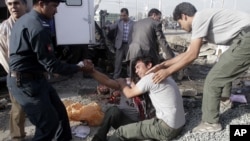 Brothers of an Afghan mini-bus driver who was killed in a suicide bombing cry at the scene, Sept. 18, 2012 in Kabul, Afghanistan. 