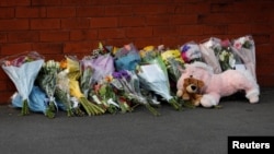 Flowers and a stuffed animal are seen behind the police cordon near the scene of a stabbing incident in Southport, Britain, July 29, 2024. (Foto: REUTERS/Temilade Adelaja