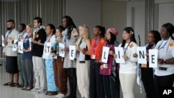 Activistas muestran carteles que forman la frase "mantengan la línea" cerca del secretario general de la ONU, António Guterres, mientras habla en durante una conferencia de prensa en la cumbre climática de la ONU COP28 en Dubái, el lunes 11 de diciembre de 2023. 