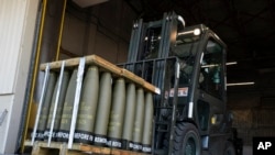 资料照片：在特拉华州的多佛空军基地，美国空军士兵驾驶叉车运送将被送往乌克兰的155毫米炮弹。(2022年4月29日)