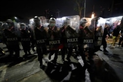 Police hold shields in formation as pro-democracy protesters demanding the release of pro-democracy activists march in Bangkok, Thailand, Feb. 10, 2021.