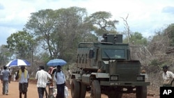 Internally displaced people walk past a military vehicle in the Zone 4 camp at Manik Farm in northern Sri Lanka, Aug. 19, 2009 (file photo)