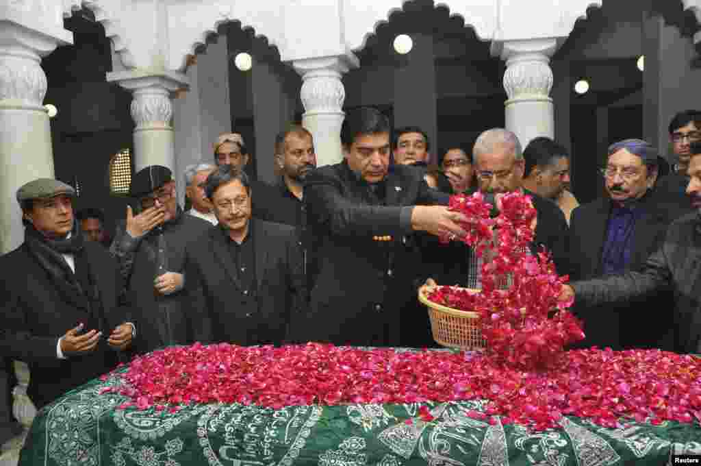 وزیر اعظم پرویز اشرف بے نظیر بھٹو کی قبر پر پھول نچھاور کر رہے ہیں