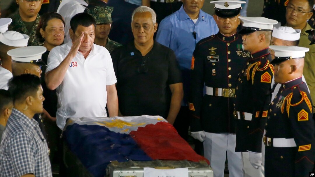 El presidente de Filipinas participa de una ceremonia ante el cuerpo del teniente de la Marina, John Frederick Savellano, uno de los doce marinos víctimas del enfrentamiento del viernes con militantes musulmanes.