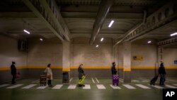 People line up to enter in a shop to buy supplies in Barcelona, Spain, Tuesday, March 17, 2020.