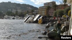 Destroyed yachts lie on the shore after windstorm and the strong sea storm in Rapallo, Italy, Oct. 30, 2018. On Saturday heavy rain caused flooding in Sicily, leaving nine dead.