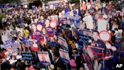 Supporters of various political parties hold placards as constituency candidates arrive for their registration for the upcoming general election, at the Thailand-Japan Youth Center stadium in Bangkok, Thailand, April 3, 2023. 