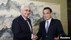 PM China Li Keqiang (kanan) berjabat tangan dengan Menlu India Salman Khurshid di Beijing (10/5). 