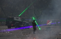 Anti-government demonstrators shine laser pointers at the police during a protest in Santiago, Chile, Nov. 12, 2019.