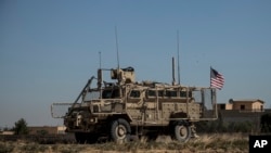 An American armored vehicle patrols with Turkish forces, as they conduct their second joint ground patrol in the "safe zone" on the Syrian side of the border with Turkey, in Rahaf village, near the town of Tal Abyad, northeastern Syria, Sept. 24, 2019.