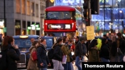 People walk along Oxford Street, amid the coronavirus disease (COVID-19) outbreak, in London, Britain, Dec. 14, 2020.