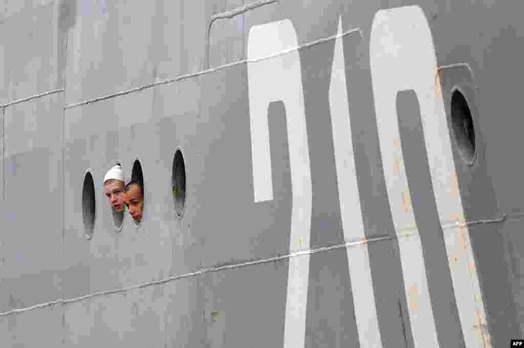 Russian sailors look through the porthole as they arrive aboard the Smolniy in Saint-Nazaire, western France.