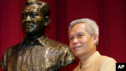 Sombath Somphone of Laos, the winner of Ramon Magsaysay Award for Community Leadership in 2005, poses with the bust of the late Philippine president, Aug. 31, 2005.