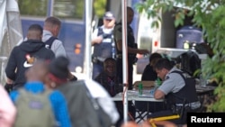 FILE - Refugees are processed by the Royal Canadian Mounted Police (RCMP) after crossing illegally into Canada at the U.S.-Canada border on Roxham Road from Champlain, New York, August 3, 2017. 