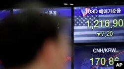 A currency trader works near the screens showing the foreign exchange rates at the foreign exchange dealing room in Seoul, South Korea, June 4, 2020.