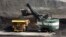 FILE - A mechanized shovel loads a haul truck with coal at the Spring Creek coal mine near Decker, Mont., April 4, 2013. A federal judge in Montana says the Trump administration failed to consider the environmental effects of resuming coal sales from federal lands.