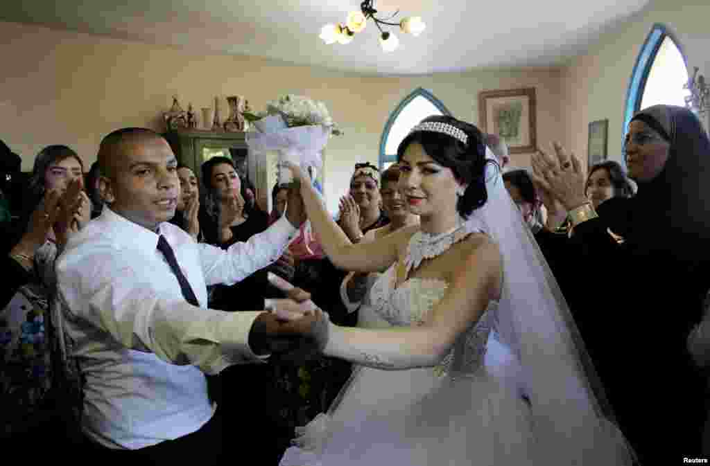 Groom Mahmoud Mansour, 26, and his bride Maral Malka, 23, celebrate with friends and family before their wedding in Mahmoud's family house in Jaffa, south of Tel Aviv, Aug. 17, 2014.
