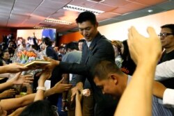 Supporters give presents to Future Forward Party leader Thanathorn Juangroongruangkit as he arrives to give a speech, at the party's headquarters in Bangkok, Thailand, Feb. 21, 2020.