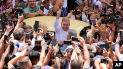 ARCHIVO - Edmundo González Urrutia, candidato presidencial de la oposición venezolana, hace la señal de victoria ante seguidores tras votar en Caracas el 28 de julio de 2024.