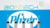 FILE - Syringes are seen in front of displayed Biontech and Pfizer logos in this illustration taken November 10, 2020.