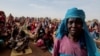 FILE: Halime Adam Moussa, a Sudanese refugee who is seeking refuge in Chad for a second time, waits with other refugees to receive a food portion from the U.N. World Food Program (WFP), near the border between Sudan and Chad in Koufroun, Chad, on May 9, 2023