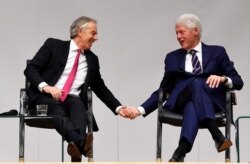 FILE - Tony Blair and Bill Clinton hold hands during an event to celebrate the 20th anniversary of the Good Friday Agreement, in Belfast, Northern Ireland, April 10, 2018.