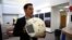FILE - Bret Greenstein, IBM Global Vice President of Watson Internet of Things Offerings, holds a clone of an artificial intelligence bot named CIMON, at the Kennedy Space Center in Florida, June 28, 2018. 