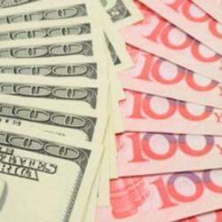 FILE - A closeup of fanned U.S. dollar and China yuan bills.