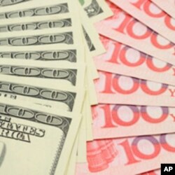 FILE - A closeup of fanned U.S. dollar and China yuan bills.