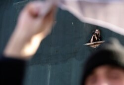 FILE - A camerawoman films the protest in Kosovo's capital, Pristina, Dec. 2, 2008.