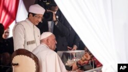 Pope Francis, right, receives a miniature model of the Istiqlal Mosque as the Grand Imam of Istiqlal Mosque Nasaruddin Umar, left, looks on during an interreligious meeting with religious leaders at the Istiqlal Mosque in Jakarta, Sept. 5, 2024. 