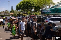 Orang-orang yang tedampak kebakaran hutan dan lahan di Maui, Hawaii antre untuk mendapatkan jatah makanan di pusat distribusi di Honokawai Beach Park di Napili-Honokawai, Maui bagian barat, Hawaii, 14 Agustus 2023. (Foto: Yuki Iwamura/AFP)