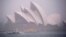 FILE - Ferries and boats pass in front of the Sydney Opera House as strong winds and heavy rain hit the city of Sydney, Australia, Nov. 28, 2018. 