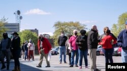 FILE - Job seekers queue outside an employment center in Louisville, Kentucky, April 15, 2021. 