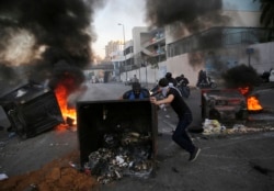 Anti-government protesters block a main highway by a garbage containers and burned tires, during ongoing protests against the Lebanese government, in Beirut, Lebanon, Nov. 4, 2019.